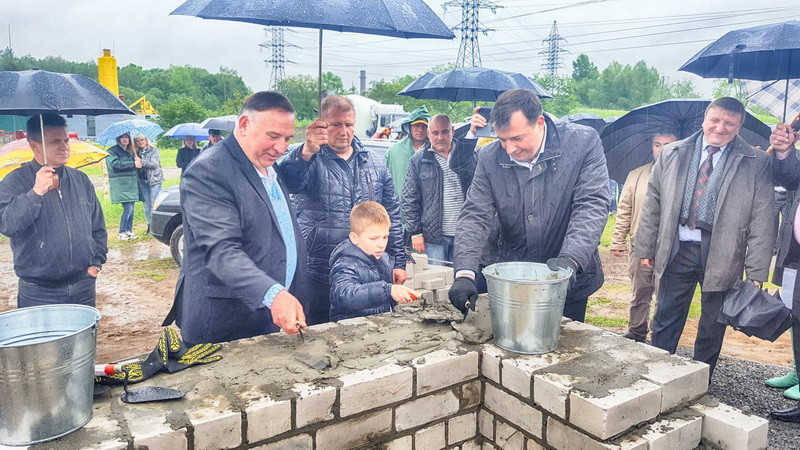 Mr. Viktor Lazar with the youngest of Lazars - Mikhailo Lazar and a head of the Chernihiv region - Valeriy Kulich are placing the first bricks and time capsule to the construction.